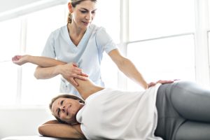 Modern rehabilitation physiotherapy worker with woman client