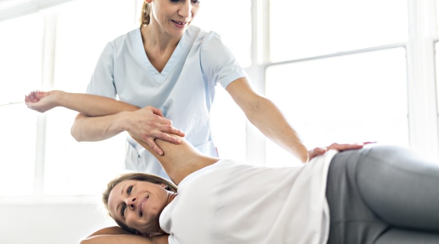 Modern rehabilitation physiotherapy worker with woman client